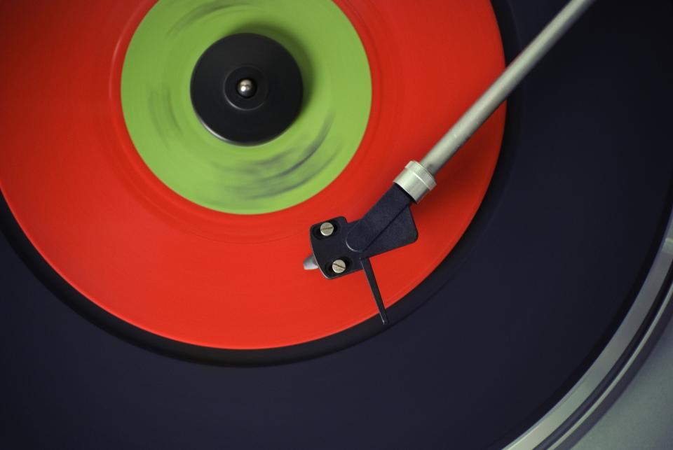 A tonearm playing a record with a green label